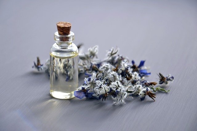 Bottle of lavender essential oil next to lavender.